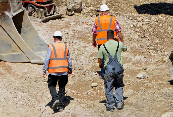 Bauarbeiter in der Sonne, © PIRO, Pixabay 3 Bauarbeiter gehen bei Sonnenschein über eine Baustelle